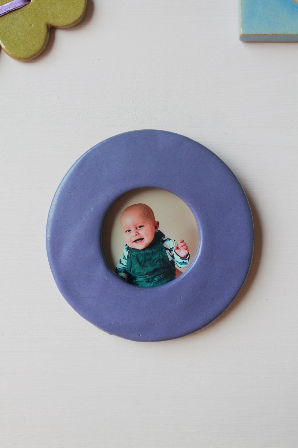 cadre photo rond et bleu avec au centre une photo de bébé souriant
