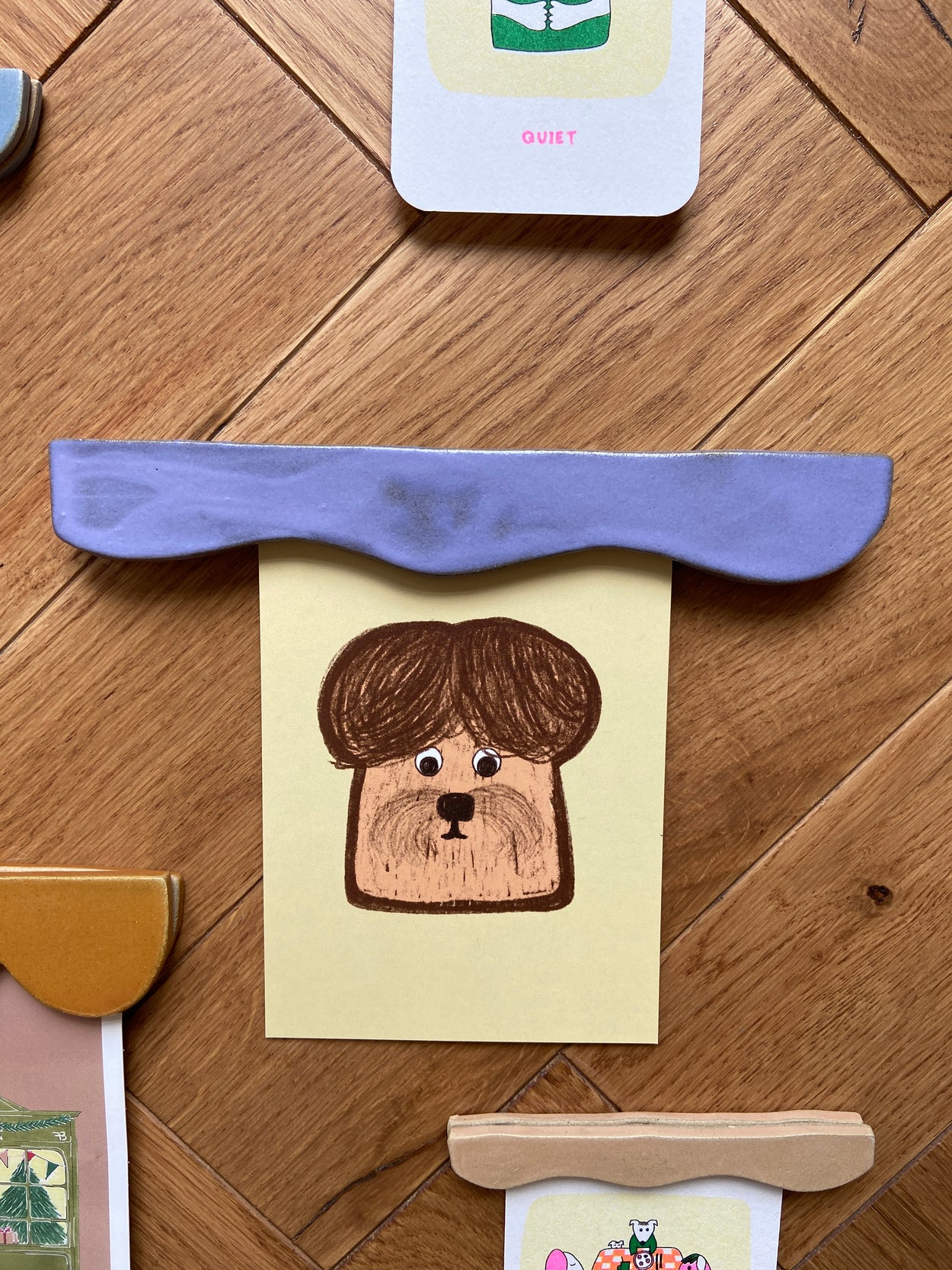 porte affiche bleu créé par Florine est Micheline contenant une affiche de Gisele et Rose représentant un chien sous la forme d'un toast