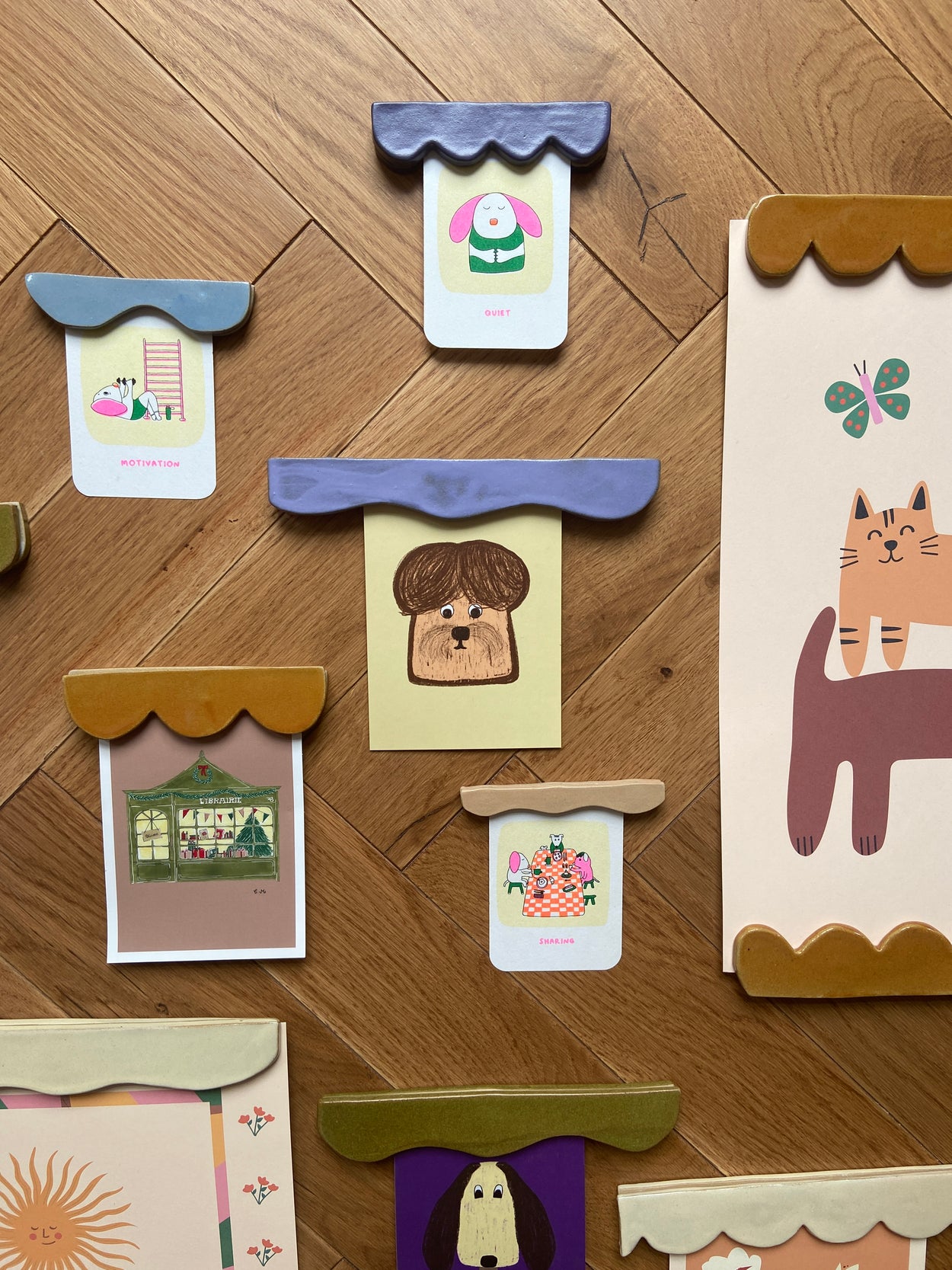 Ensemble de portes affiches réalisés par Florine est Micheline sur un parquet chevron