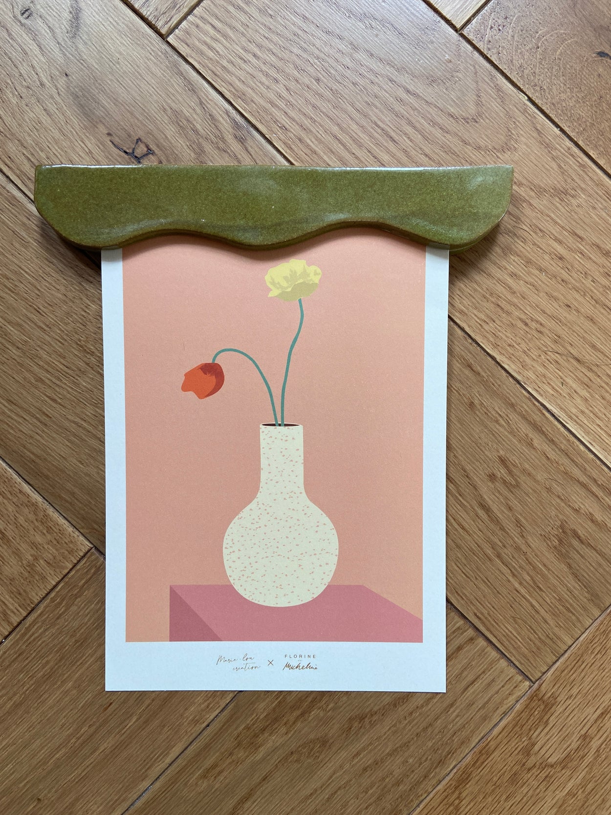 Porte affiche verte portant une affiche représentant un vase de Florine est Micheline