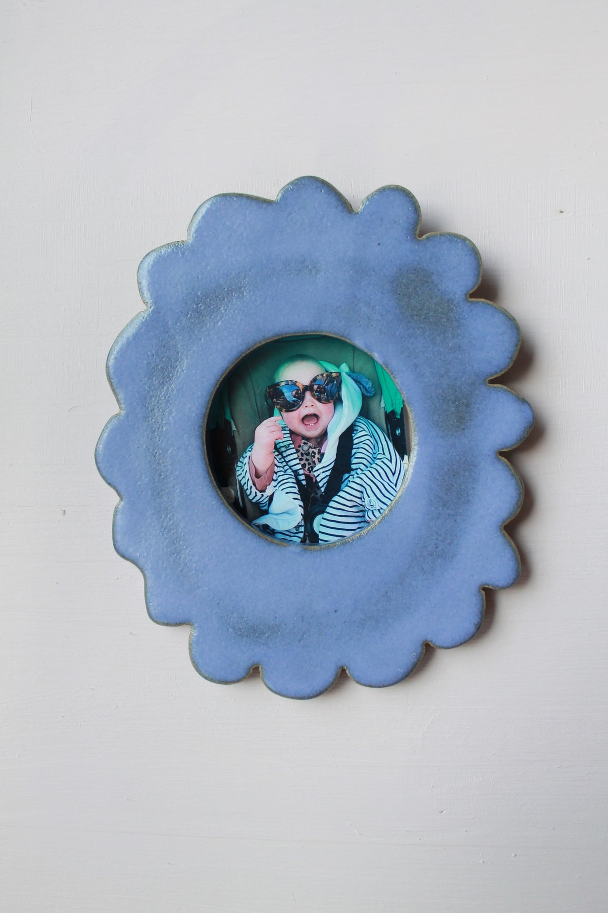 Cadre photo rond et dentele bleu avec au centre une photo de bébé