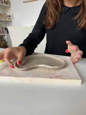 Photo d'une personne manipulant une assiette en ceramique réalisée lors d'un atelier de poterie à Lille
