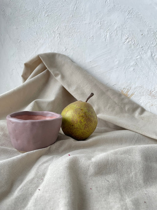 Photo d'une tasse rose accompagné d'une poire